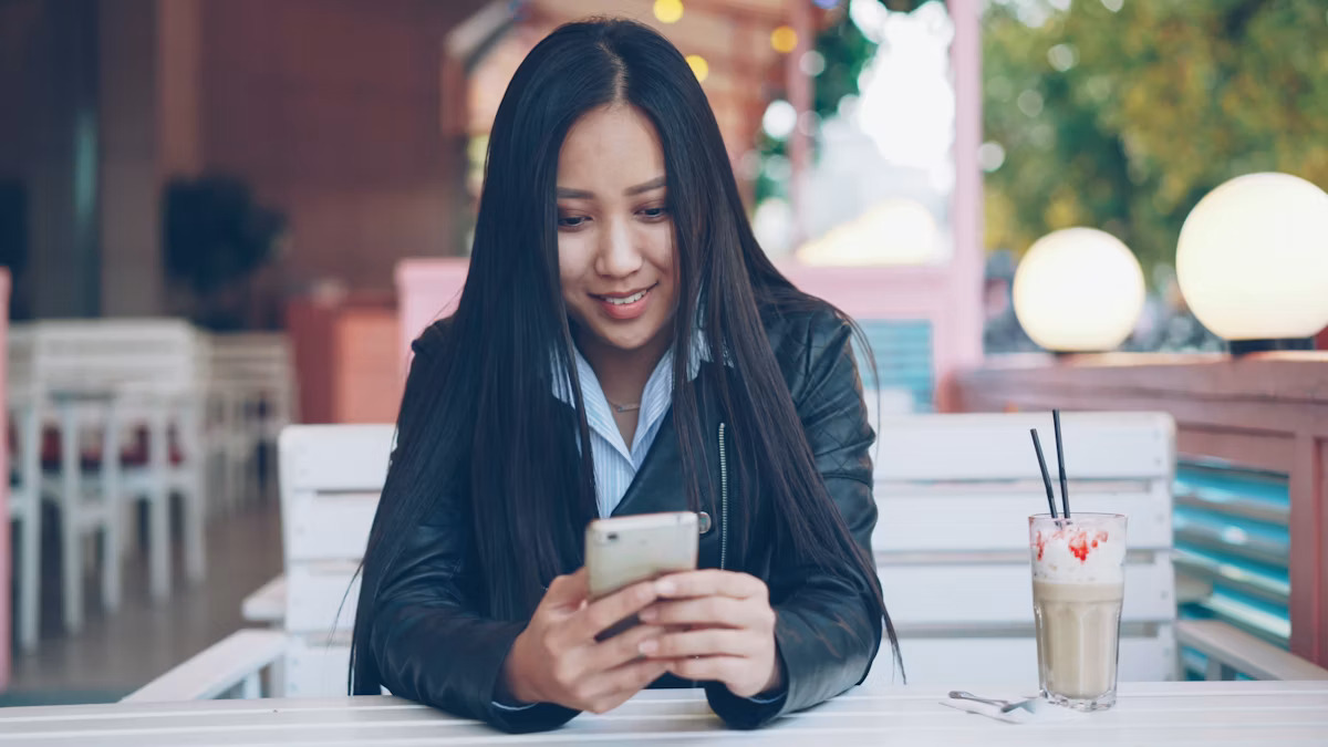Woman smiling while looking at her phone